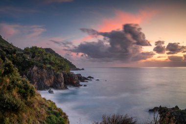 Gün batımında Basilicata 'daki Maratea Sahili' nde görkemli sakin bir koy ve uçurum manzarası.