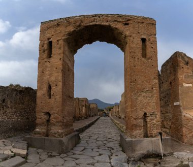 Pompei, İtalya - 25 Kasım 2023: Pompei antik kentinde taş kemer ve uzun cadde