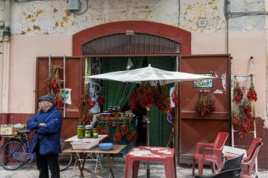 Bari, İtalya - 27 Kasım 2023: Bari Vecchio 'da biber ve zeytin satan yaşlı bir adamla köşedeki dükkan