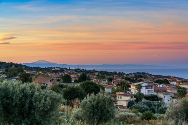 Gündoğumunda Calabria 'daki Ricadi köyü ve arka planda Etna Dağı manzarası.