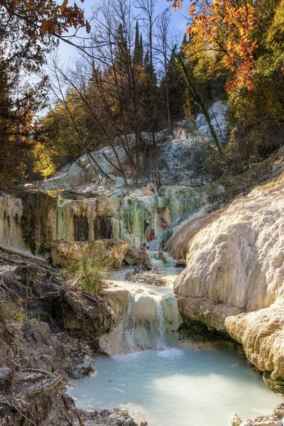 Bagni San Filippo, İtalya - 17 Kasım 2023: İnsanlar Bagni San Filippo 'nun kalsiyum karbonat yataklarının ve birçok havuzun ortasındaki kaplıcaların keyfini çıkarıyorlar.