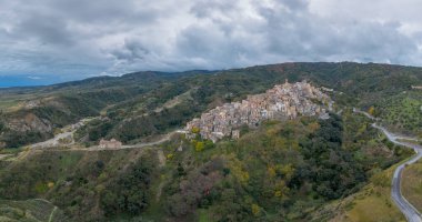 Badolato, İtalya - 15 Aralık 2023: Calabria 'daki Badolato dağ köyü ve kilisesinin insansız hava aracı perspektifi