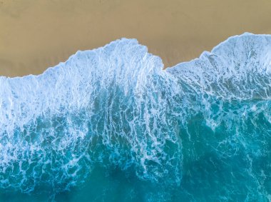 Tropea 'daki altın rengi Rotonda Sahili' nin tepesinde turkuaz su ve dalgalar kıyıya vuruyor.