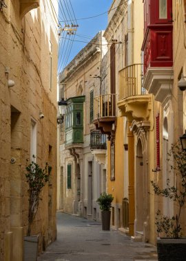 Rabat, Malta - 22 Aralık 2023: Renkli Gallarija balkonlarıyla Rabat 'ın tarihi şehir merkezinde dar pitoresk şehir caddesi
