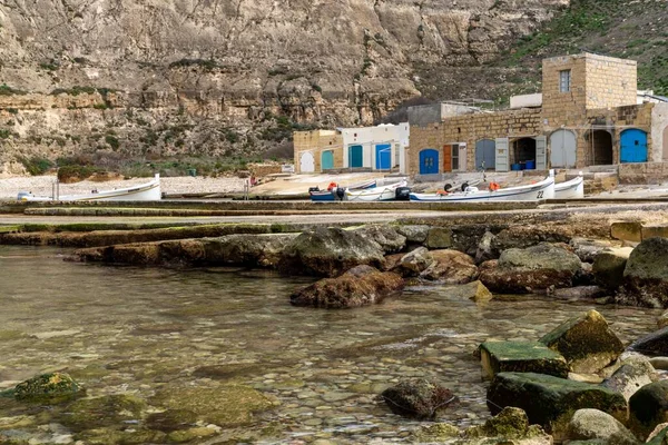 Dwejra, Malta - 19 Aralık 2023: Malta 'daki Gozo Adası' ndaki İç Deniz lagünündeki renkli balıkçı köyü ve tekneleri