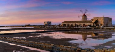 Paceco, İtalya - 3 Ocak 2024: Günbatımında Paceco 'nun yel değirmeni ve tuz yassı müzesinin manzarası