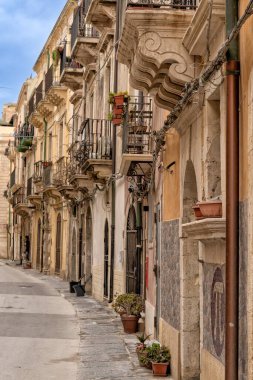 Syracuse, İtalya - 28 Aralık 2023: Isola di Ortigia 'nın merkezinde eski kasaba caddesi ve balkonları