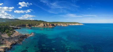 Cala Xarraca körfezinin turkuaz sularıyla kuzey İbiza 'nın yeşil ve engebeli kıyıları havadan görülebilir.