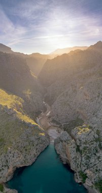 Kuzey Mallorca 'nın engebeli dağ kıyısındaki Torrent de Pareis Vadisi ve plajının dikey görüntüsü