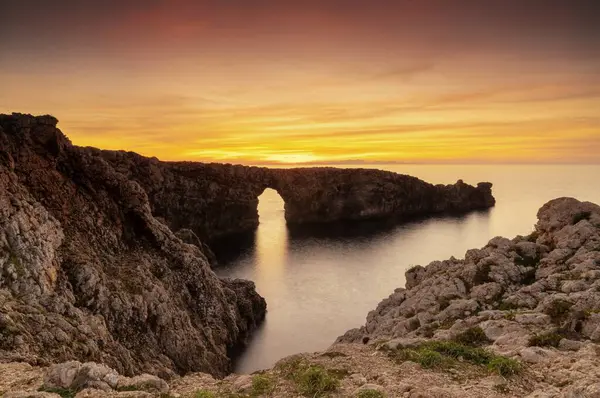 Stock image A view of the landmark stone arch of Pont d'en Gil on Menorca Island at sunset