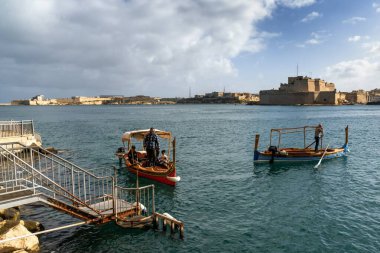 Valletta, Malta - 23 December, 2023: Maltese gondolieri bringing people across the Grand Harbor from the Three Cities to Valletta clipart