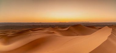 A view of the sand dunes at Erg Chebbi in Morocco at sunset clipart