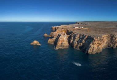 Punta Nati deniz fenerinin ve Menorca 'nın kuzeybatısındaki sahil kayalıklarının insansız hava aracı görüntüsü.