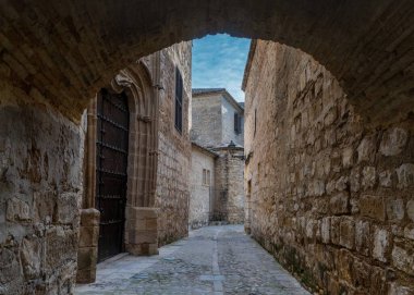 Baeza, İspanya - 5 Nisan 2024: Baeza 'nın tarihi şehir merkezinde Paseo de las Murallas yolu boyunca dar sokak ve taş kemer