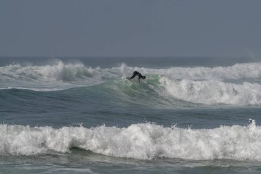 Sidi Ifni, Fas - 17 Mart 2024: Sidi Ifni, Güney Fas kıyılarında büyük bir dalgada sörf yapan adam