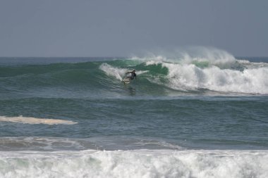 Sidi Ifni, Fas - 17 Mart 2024: Sidi Ifni, Güney Fas kıyılarında büyük bir dalgada sörf yapan adam