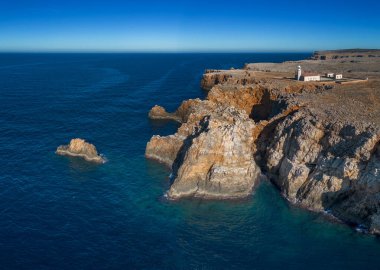 Punta Nati deniz fenerinin ve Menorca 'nın kuzeybatısındaki sahil kayalıklarının insansız hava aracı görüntüsü.