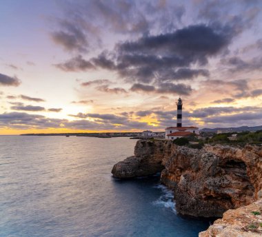 Günbatımında Mallorca 'nın doğusundaki Portocolom Deniz Feneri manzarası