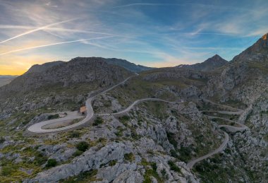 Top-down aerial view of the Nus de Sa Corbata hairpin turn in the Serra Tramuntan of Mallorca near Coll de Reis mountain pass clipart