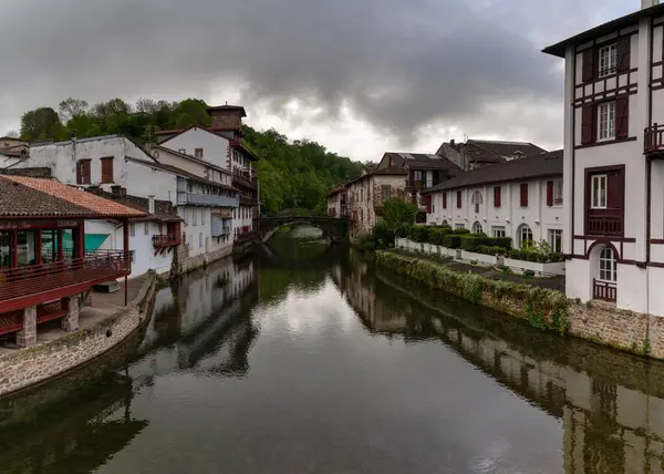 stock image Saint-Jean-Pied-de-Port, France - 17 April, 2024: view of the old town of Saint-Jean-Pied-de-Port with the stone bridge over the Nive River