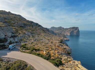 Kuzey Mallorca 'daki Cap de Formentor' a giden virajlı dağ yolunda bir karavan.