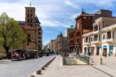 Leon, İspanya - 13 Nisan 2024: Calle Ancha caddesi ve Leon şehir merkezinin ön planda turistik bir şehir turu treni ile manzarası