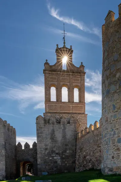 stock image Avila, Spain - 8 April, 2024: vertical view of the Avila city walls and the Puerta del Carmen with a sunstar