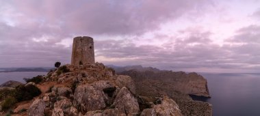 A view of the Albercutx watchtower at Cap de Formentor in northwestern Mallorca at sunrise clipart
