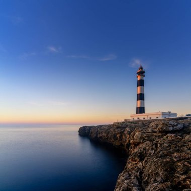 Güneş doğduktan hemen sonra Menorca Adası 'ndaki Kaptan d' Artrutx deniz fenerinin manzarası.
