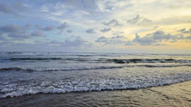 Dalgalı deniz manzarası Parangtritis sahilinde bulutlu bir gökyüzü, Yogyakarta