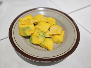 Dilimlenmiş mangolar tabakta servis edilir.