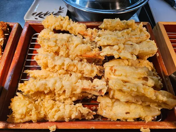 Çıtır çıtır karides tempura, bir tepside güzelce istiflenmiş klasik ve lezzetli bir Japon ziyafeti sunuyor.