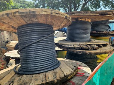 Sarılmış siyah kablolar düzgünce bir ağılda düzenlenmiş, endüstriyel organizasyon sergileniyor.