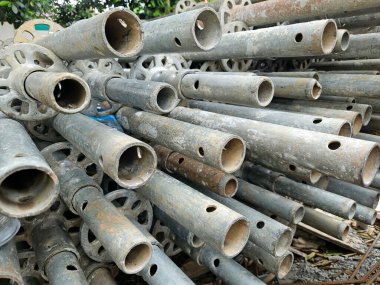 Endüstriyel hazırlık ve verimliliği vurgulayarak, bir avluda depolanmış yapı iskelesi bileşenleri