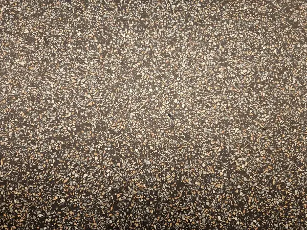 Klasik terrazzo döşemesi. Koyu bir tabanı ve dağınık taş parçaları var.