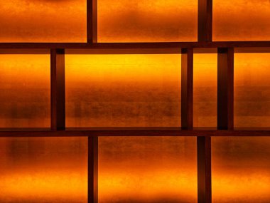 Minimalist ahşap şebeke sıcak arka ışıkla aydınlatılıyor..