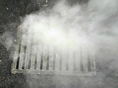 Sokaktan gelen buhar gizemli bir atmosfer yaratıyor.