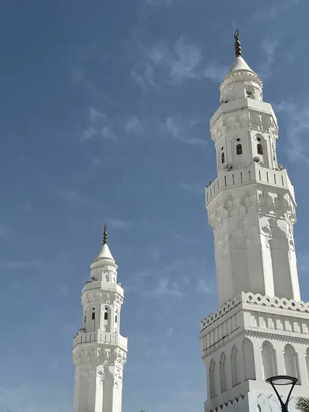 Zarif beyaz cami minareleri açık mavi gökyüzüne karşı dik dururlar.