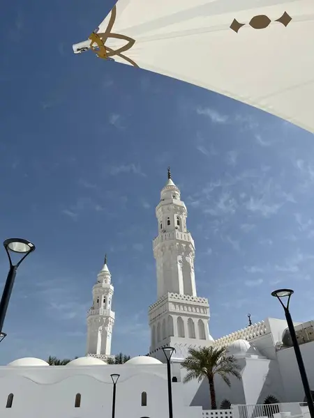 Tarihi bir caminin ikiz minareleri parlak gökyüzü altında zarafetle yükseliyor.