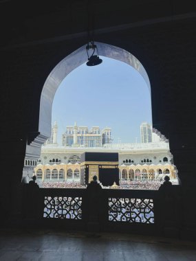 Mescid-i Haram 'ın içinde süslü bir kemer tarafından çerçevelenmiş Kabe manzarası, Makkah