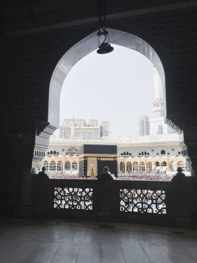 Mescid-i Haram 'ın içinde süslü bir kemer tarafından çerçevelenmiş Kabe manzarası, Makkah