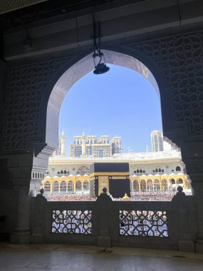 Mescid-i Haram 'ın içinde süslü bir kemer tarafından çerçevelenmiş Kabe manzarası, Makkah