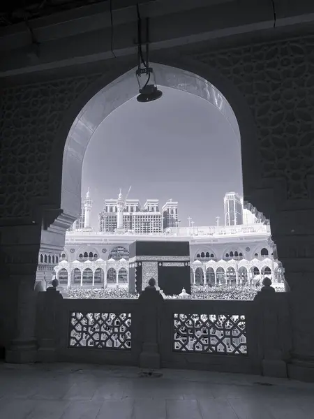 Mescid-i Haram 'ın içinde süslü bir kemer tarafından çerçevelenmiş Kabe manzarası, Makkah