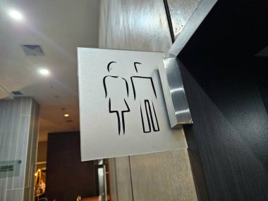 Duvar arkasına asgari tasarım tarzında tuvalet tabelası monte edilmiş