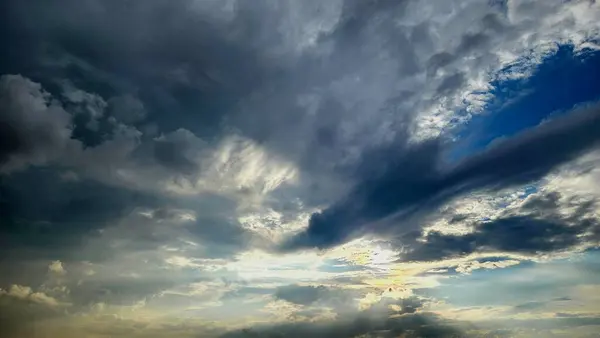 Güneş ışınlarının geçtiği dramatik bulutlu gökyüzü, arka planda, hava temalarında veya yaratıcı ve editör projelerinde atmosferik ruh hali konseptlerinde kullanılmak için idealdir.