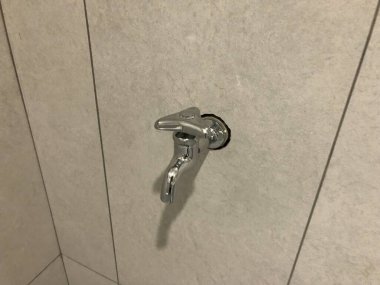 Beyaz banyo fayanslarına parlayan krom duvar musluğu. Tesisat, İnşaat, Sağlık Hizmetleri, Ev Hizmetleri ve Eğitim Diyagramı Temaları İçin Uygun