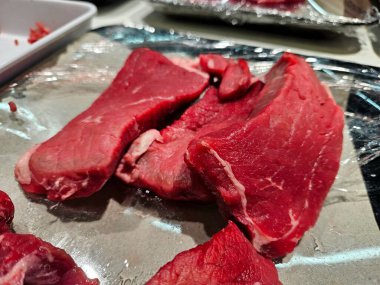 Tepside kırmızı sığır eti dilimlerinin yakın çekimi, tazelik ve kaliteyi gösteriyor. Kasap, et endüstrisi, yemek pişirme, mutfak içeriği, yemek hazırlama veya protein temaları için harika