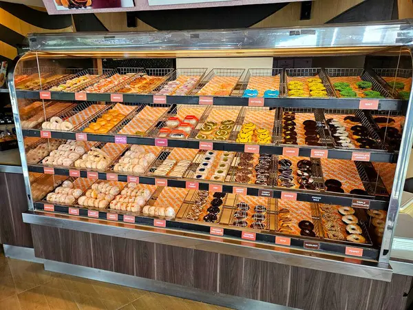 Fırın vitrinine yerleştirilmiş çeşitli çörekler, canlı ve cezbedici. Yemek için ideal, tatlı içeriği, tatlı ve atıştırmalık teması