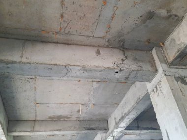 Tamamlanmamış bir binada güçlendirilmiş beton sütun ve kiriş yapısı biçimsel izler ve yapısal hizalama gösteriyor. Beton yapı, inşaat mühendisliği ve inşaat ilerleme teması için uygun