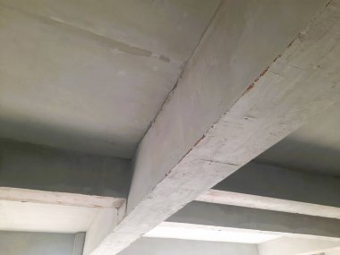 Tamamlanmamış bir binada güçlendirilmiş beton sütun ve kiriş yapısı biçimsel izler ve yapısal hizalama gösteriyor. Beton yapı, inşaat mühendisliği ve inşaat ilerleme teması için uygun